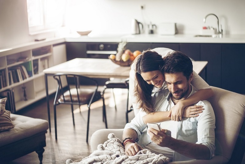 photo of woman hugging man on couch